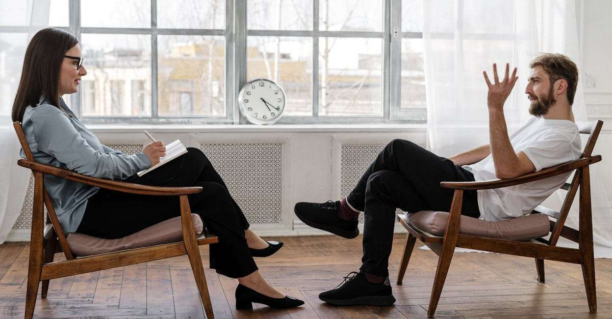 A therapist engaging in a counseling session with a male patient to support mental health, Promote Emotional Health